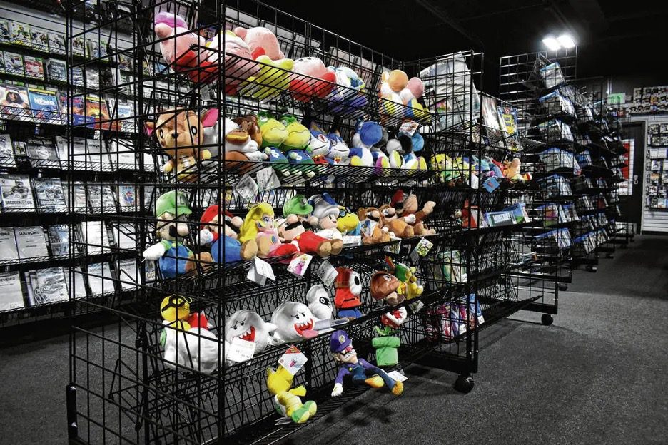 Kirby, Mario, Animal Crossing, and Zelda plushies on a wire display at Game World’s South Indianapolis location
