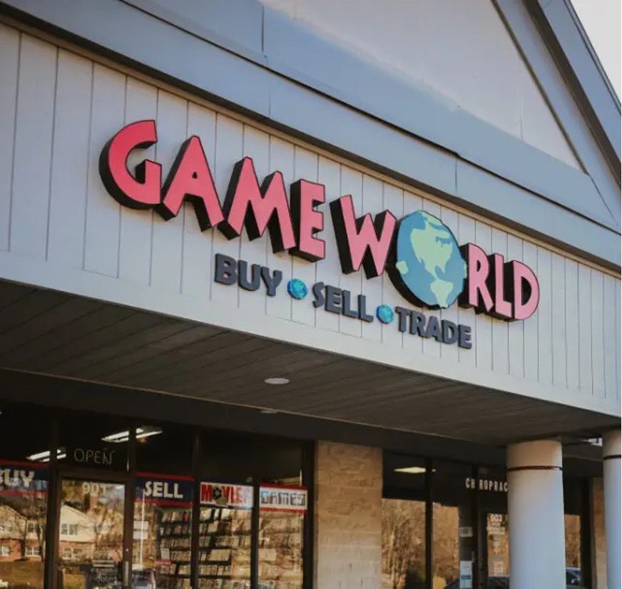 Exterior of the 901 S. College Mall Rd. Game World store with a “Buy • Sell • Trade” sign above the entrance.