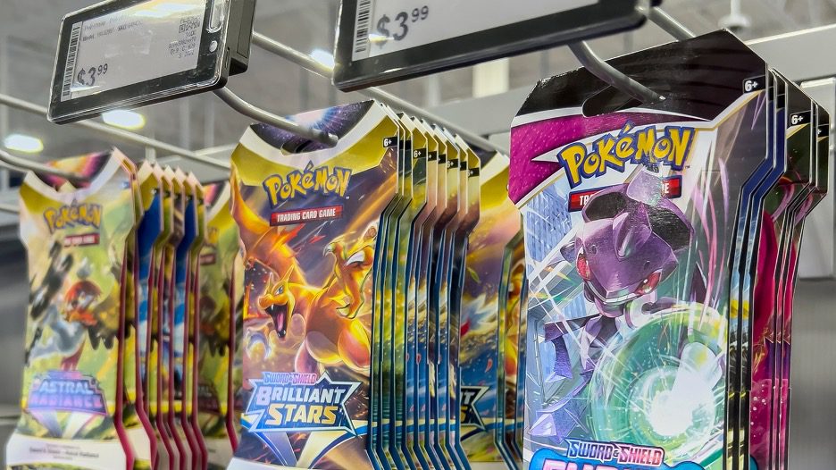 Pokémon Trading Card Game booster packs hanging on a retail store shelf, including Sword & Shield sets like Brilliant Stars and Astral Radiance